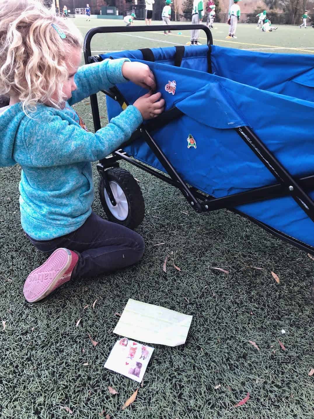 girl putting stickers on a wagon 