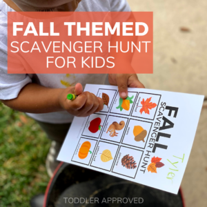 kid holding Fall scavenger hunt card