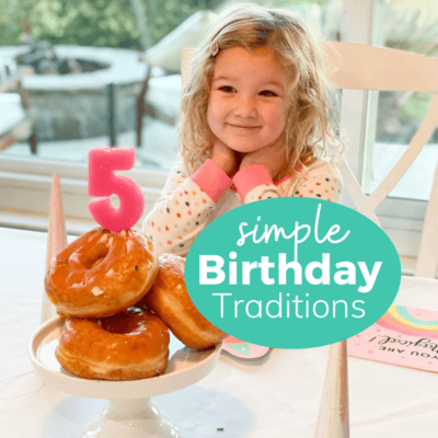 little girl smiling looking at a pile of donut holes with a #5 candle on top